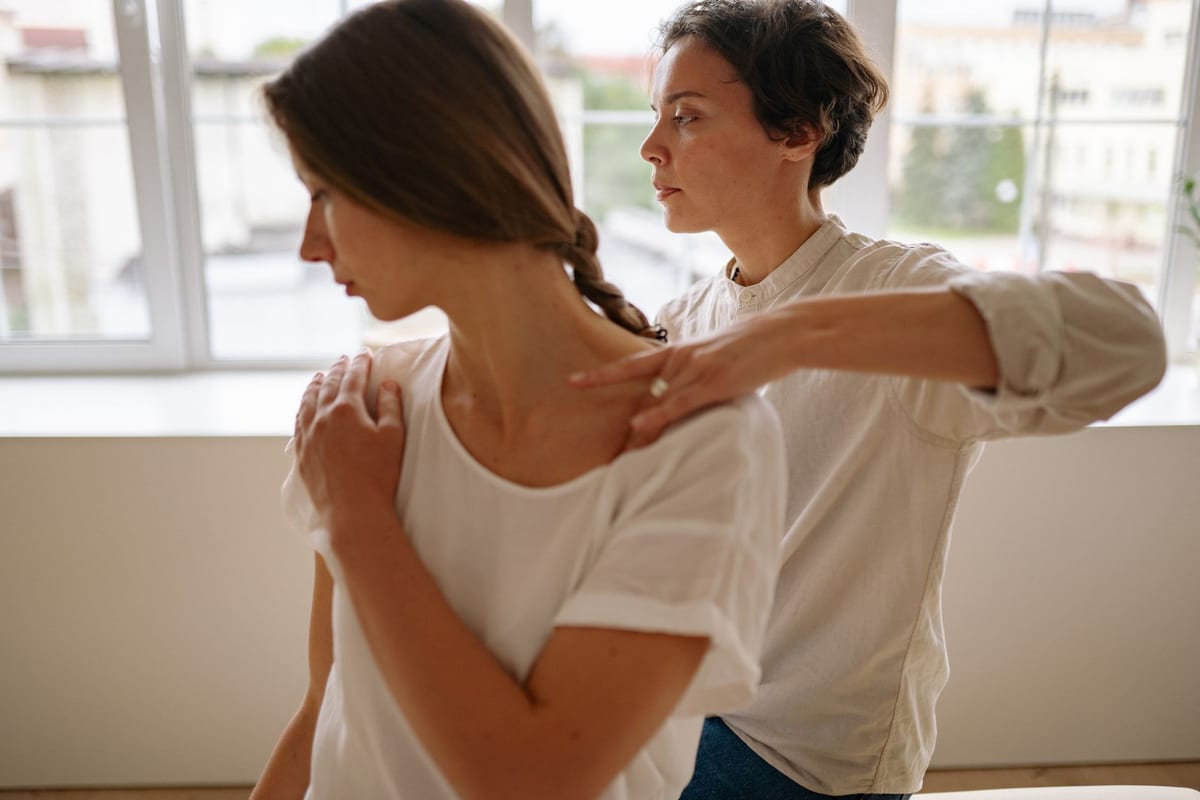 A seated patient having a shoulder treatment