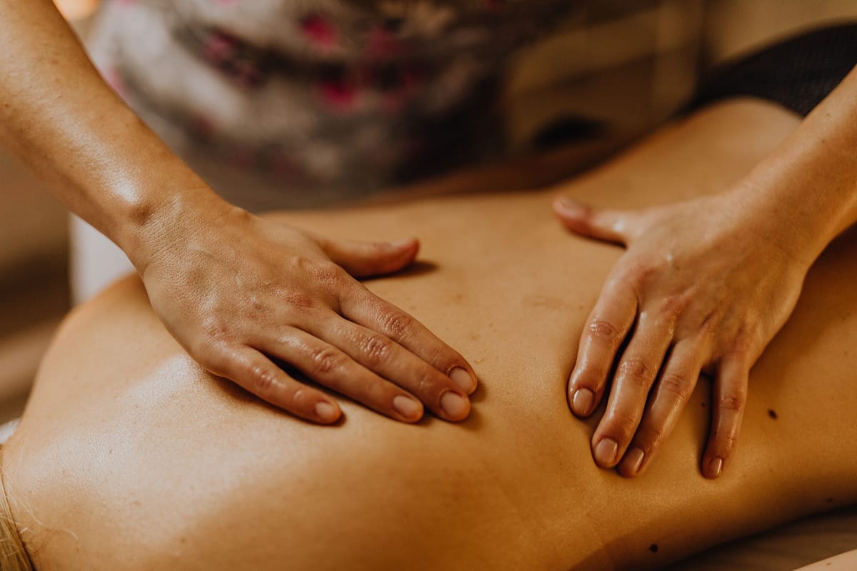 Hands working across a patient's back during a massage treatment
