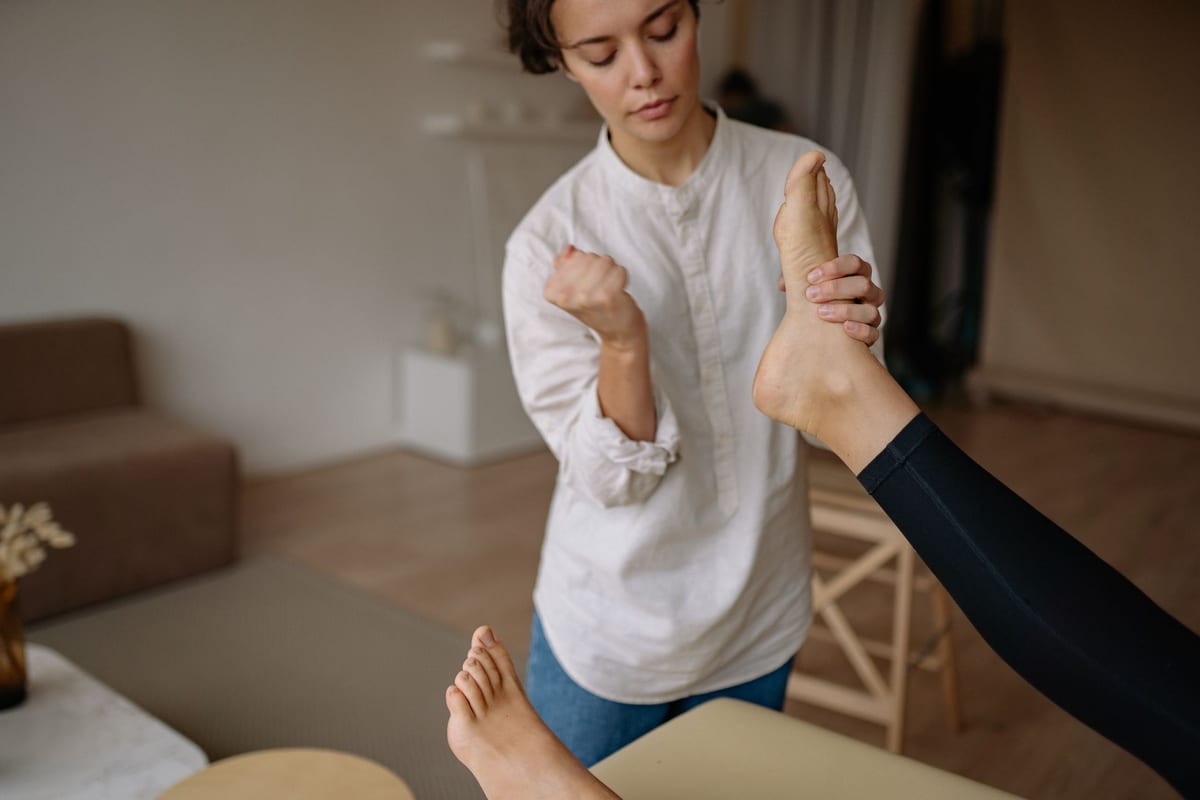 A practitioner working on a patient's foot on a treatment table